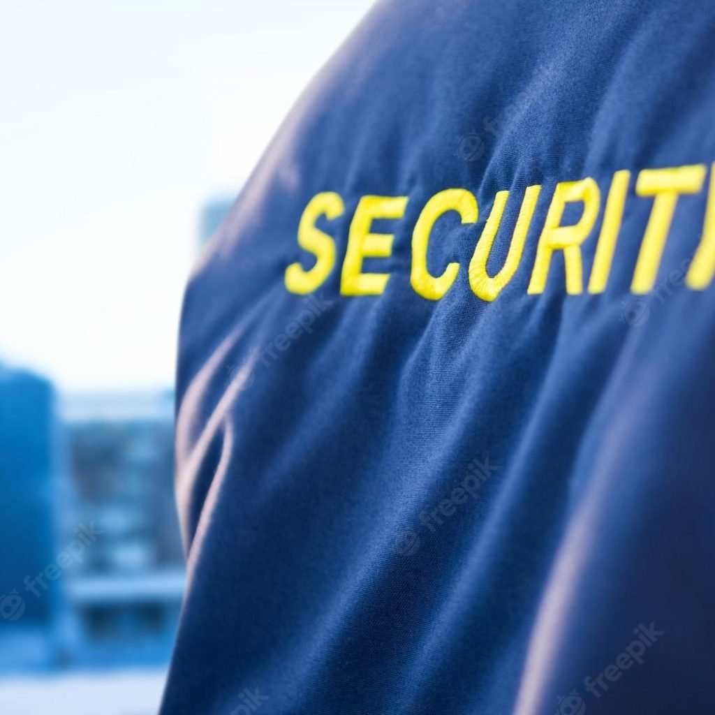 back-security-guard-jacket-against-blurry-window-showing-city_1134-21846